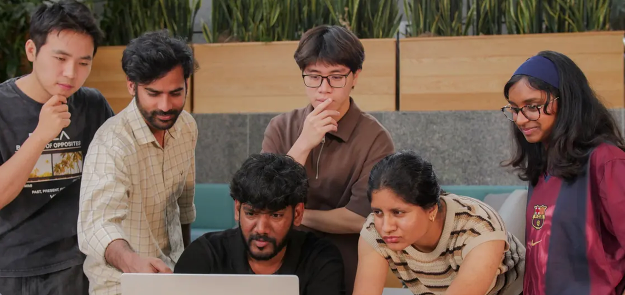 The Dakmod team gathered around a laptop